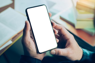 Mockup image blank white screen cell phone.man hand holding texting using mobile on desk at coffee shop.background empty space for advertise text.people contact marketing business,technology 