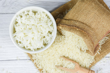 Thai rice white on bowl wooden background - raw and cooked jasmine rice grain agricultural products for food in Asian