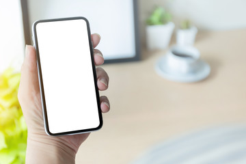 Mockup image blank white screen cell phone.man hand holding texting using mobile on desk at office.background empty space for advertise text.people contact marketing business,technology 