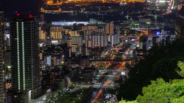 Timelapse Kobe highrise downtown with bright night illumination and main multi-lane metropolis highway with car lights traces