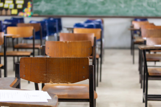 Selective Soft And Blur Focus.old Wooden Row Lecture Chairs In Dirty Classroom In Poor School.study Room Without Student.concept For Education In Third World ,donate And Charity,background Text.