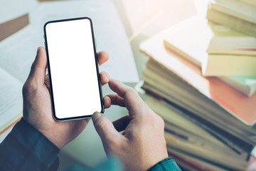 Mockup image blank white screen cell phone.man hand holding texting using mobile on desk at office.background empty space for advertise text.people contact marketing business,technology 
