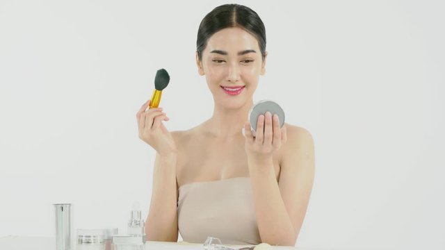 Beautiful woman face with nice applies make up by Compact Powder brush