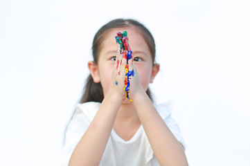Portrait of little girl and hand splicing on both sides with colorful painted over white background. Focus at kid hands.