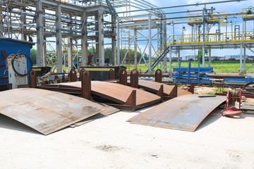An open-air production site at an industrial plant, a workshop for welding large iron metal barrels and containers made of metal sheets. Manufacture, construction of equipment