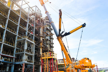 Construction and installation work with a powerful construction crane of a large new industrial oil...