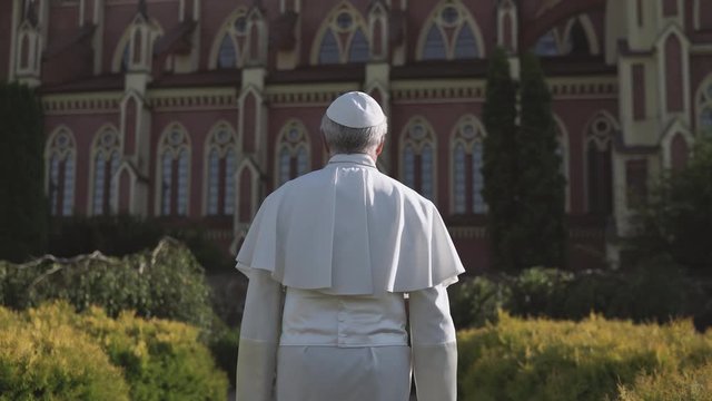 Religion: pope walks through the Vatican garden at sunset