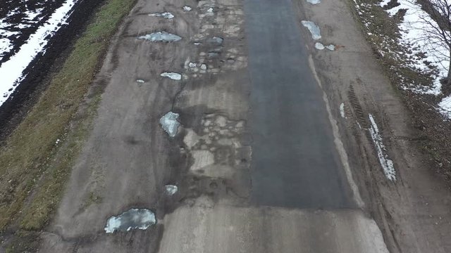 potholes Very bad road is completely covered with defects in the surface, drone view