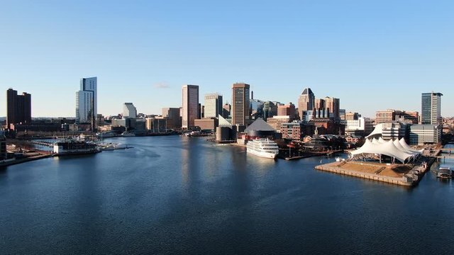 Cinematic wide aerial of Baltimore Inner Harbor, skyscapers, cruise ship, aquarium, Chesapeake Bay