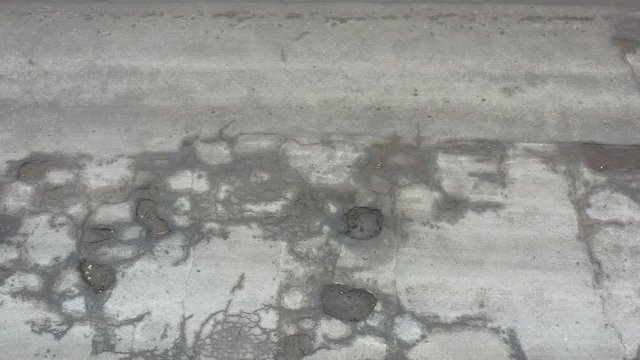 potholes Very bad road is completely covered with defects in the surface, drone view