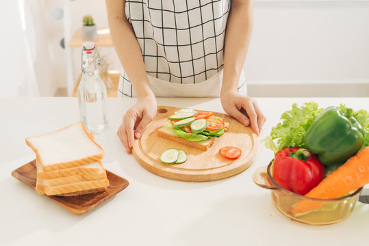 Woman Preparing Healthy Breakfast Making Delicious Sandwich In Kitchen. Good Dieting Concept.