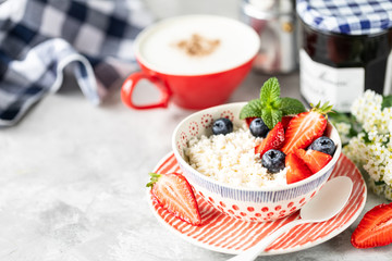 Cottage cheese with berries, jam, fresh strawberries and a cup of coffee with cream for breakfast. The recipe for the holiday Valentine's Day. Copy space