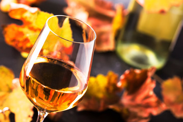 White wine glass and wine bottle on gray background with copy space