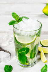Mojito with lime slices and ice in a glass cup