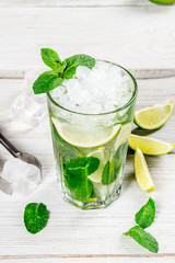 Mojito with lime slices and ice in a glass cup