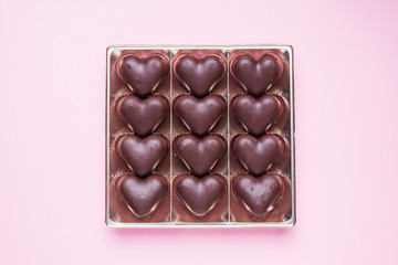 Concept Valentine's Day. Chocolate candies, hearts on a pink background