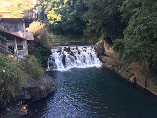 wide waterfall with green trees around