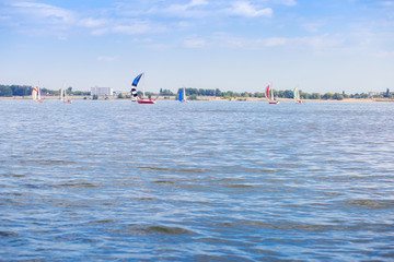 Sailing regatta is on the Volga River. Many yachts with sails on the water