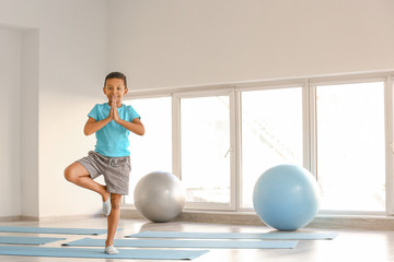Little African-American boy practicing yoga in gym © Pixel-Shot