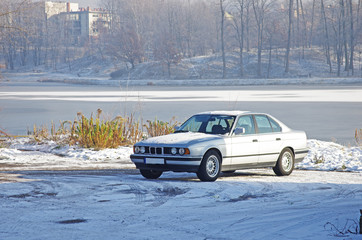 Stary samochód nad brzegiem zalewu w zimę © Patdrig Torc