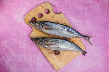 Mackerel on a pink background. Raw fish Top view,cooking concept. Free copy space.