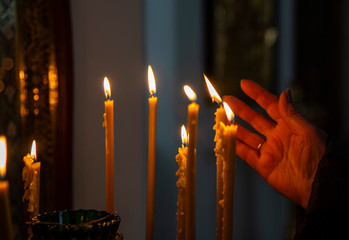 Burning in the dim light of candles in the Christian Church.