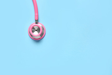 Modern stethoscope on color background