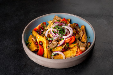 Ojahuri with onions, meat, pomegranate shot on a black background