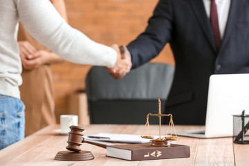 Scales of justice, book and gavel on table of lawyer in office