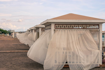 White beach canopies at sunset. Luxury beach tents at luxurious beach resort. Summer beach concept.