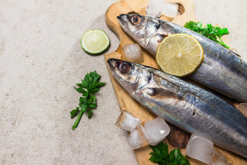 Raw mackerel with spices, herbs and cooking warel on table top view.