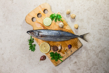 Raw mackerel with spices, herbs and cooking warel on table top view.
