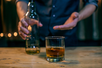 Barman pouring whiskey whiskey glass