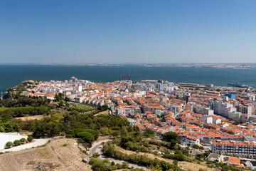 Fototapeta premium Almada city and Tagus River in Portugal viewed from above on a sunny day in the summer.