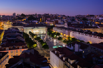 View of the Rossio Square (Praca do Rossio) in the Baixa district and beyond from above in Lisbon, Portugal, in the evening.