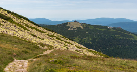 Fototapeta na wymiar Szrenica hill with Gory Izerskie mountains on the background from hiking trail bellow Labsky Szczyt hill in Karkonosze mountains in Poland