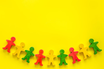 Team work, teambuilding concept. People cutouts on yellow background top-down copy space