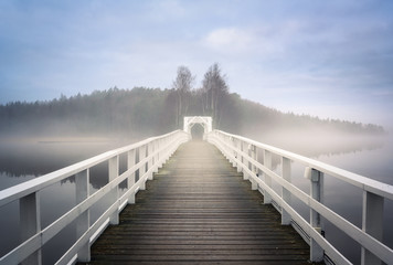 Old wooden bridge with mist haze mood and calm air at autumn morning in Finland - 314414155