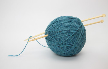 Blue wool and knitting needleson