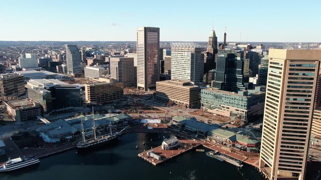 High aerial shot of Baltimore Inner Harbor skyline, skyscrapers, boats, dock, pier, tourist attractions, and business district
