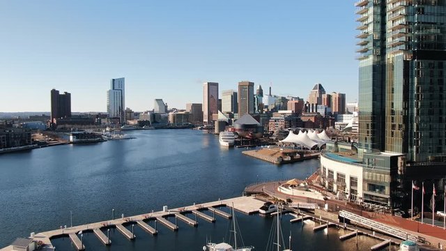 Aerial reveal of Baltimore Inner Harbor marina, buildings, attractions, downtown skyline
