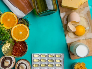 Products containing vitamin D with capsules, on blue background, top view