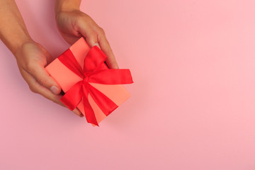 gift in female hands on a colored background top view. - Image