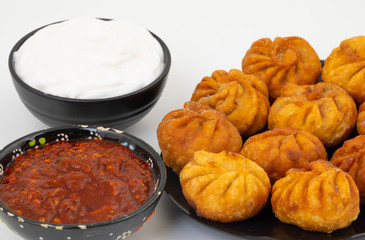 Fried Momos is a Traditional Dumpling Food From Nepal Served with Schezwan Sauce & Cream