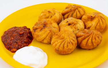 Fried Momos is a Traditional Dumpling Food From Nepal Served with Schezwan Sauce & Cream