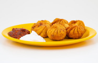 Fried Momos is a Traditional Dumpling Food From Nepal Served with Schezwan Sauce & Cream