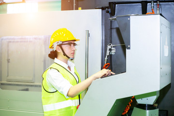 Asian woman engineer or business women are controlling machines in industrial plants.