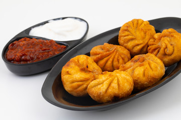 Fried Momos is a Traditional Dumpling Food From Nepal Served with Schezwan Sauce & Cream