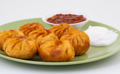 Fried Momos is a Traditional Dumpling Food From Nepal Served with Schezwan Sauce & Cream
