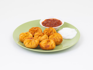Fried Momos is a Traditional Dumpling Food From Nepal Served with Schezwan Sauce & Cream